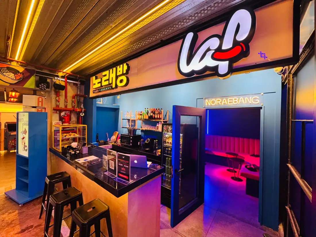 Barra de LAF CLUB con cartel luminoso y entrada a la sala Noraebang