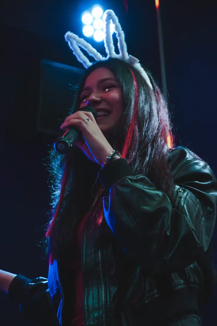 Clienta sonriendo con orejas de fiesta mientras canta en LAF CLUB