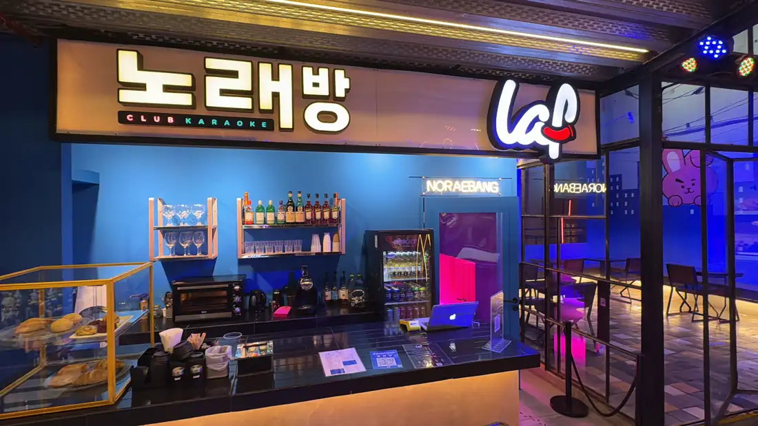 Frente de LAF CLUB con cartel 노래방 Club Karaoke en el Mercat Villa Crespo